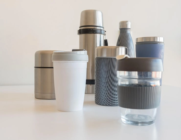 Various reusable drinkware items on a white surface